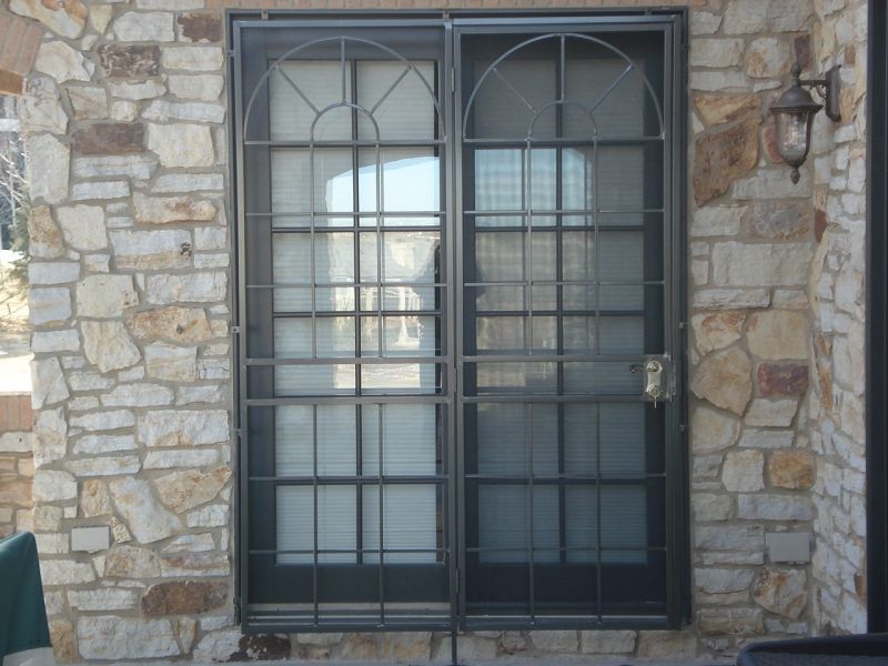 A sliding glass door with a wrought iron frame