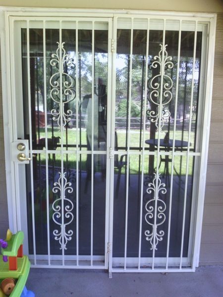 A sliding glass door with a wrought iron gate
