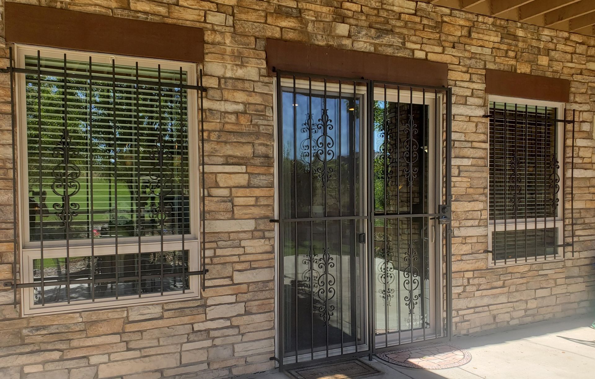 A brick building with a sliding glass door and two windows.