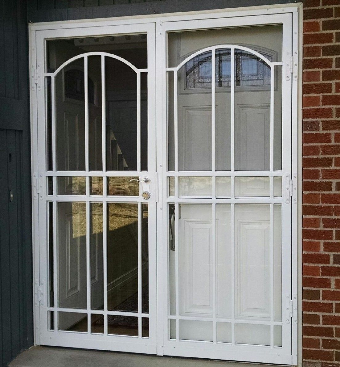 A white door with a brick wall behind it
