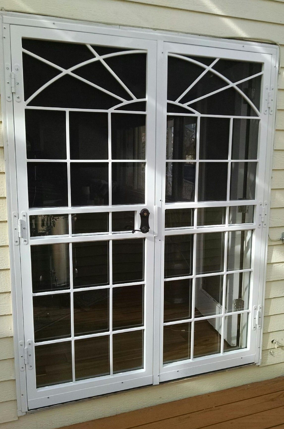 A pair of white screened in sliding glass doors on a house