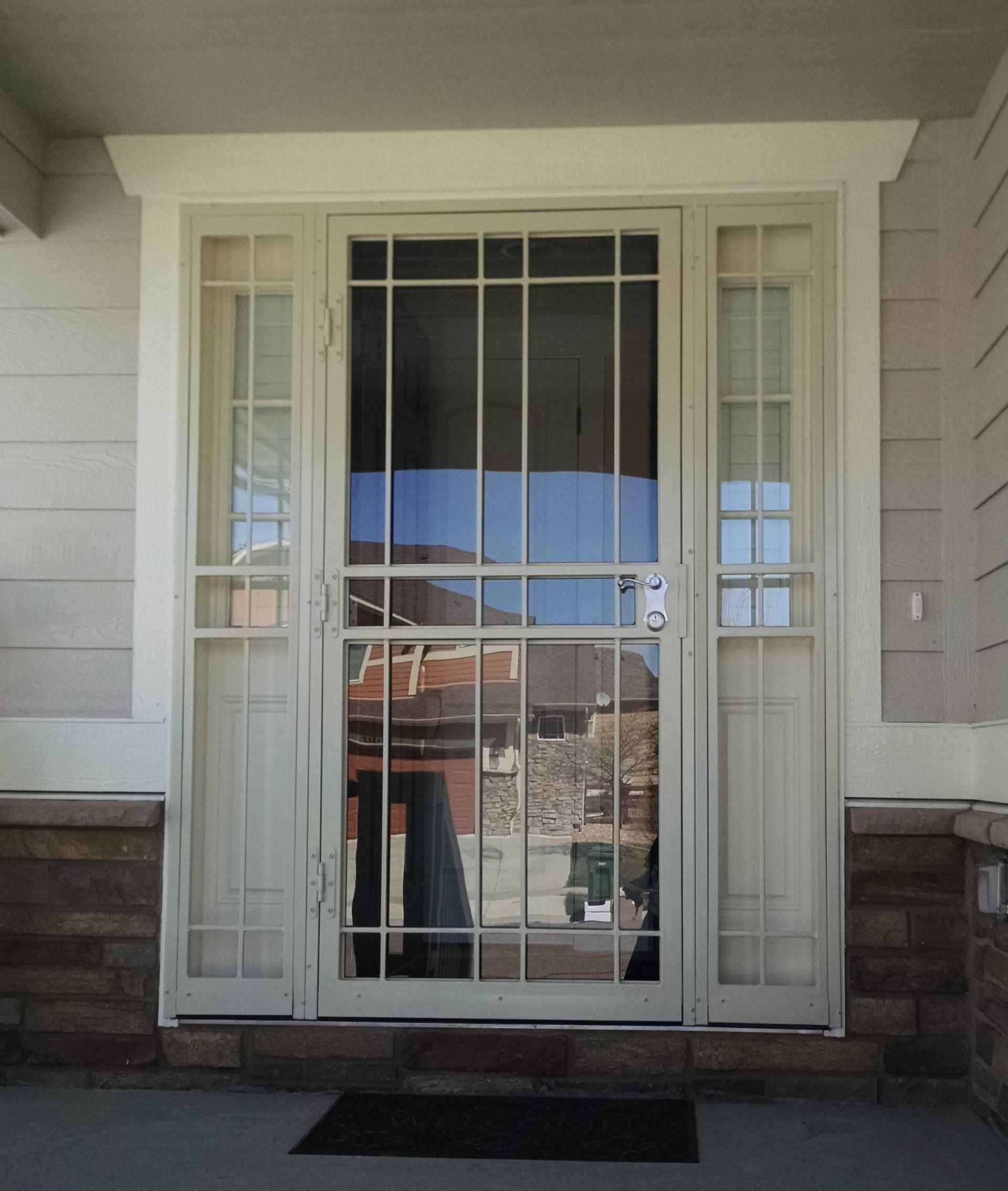 A white door with a reflection of a house in it