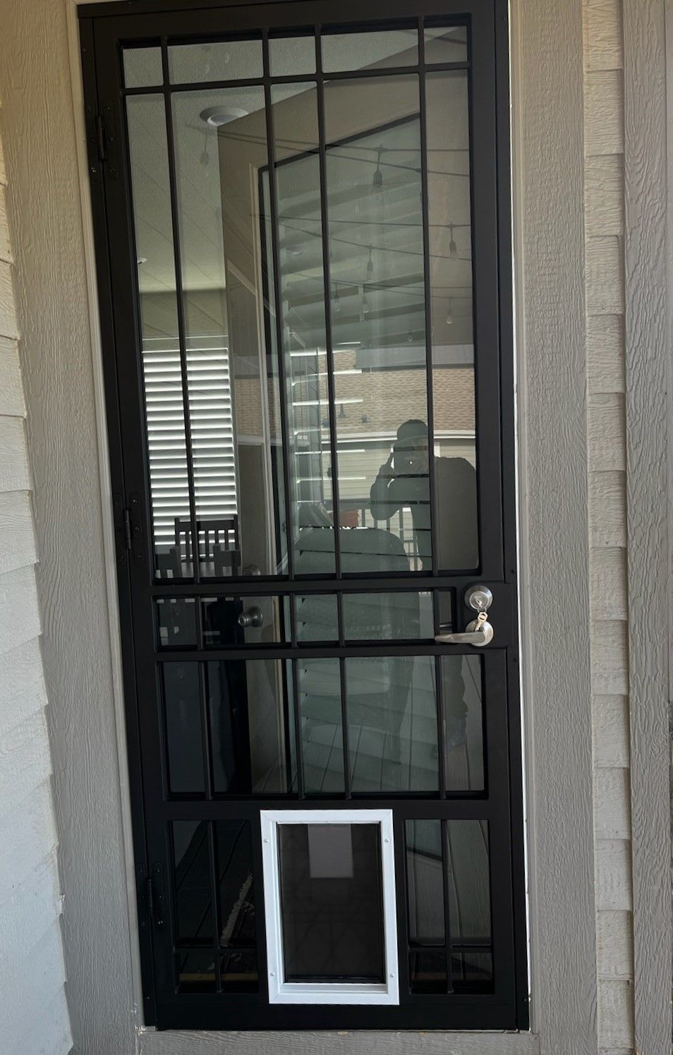 A black door with a white dog door in it