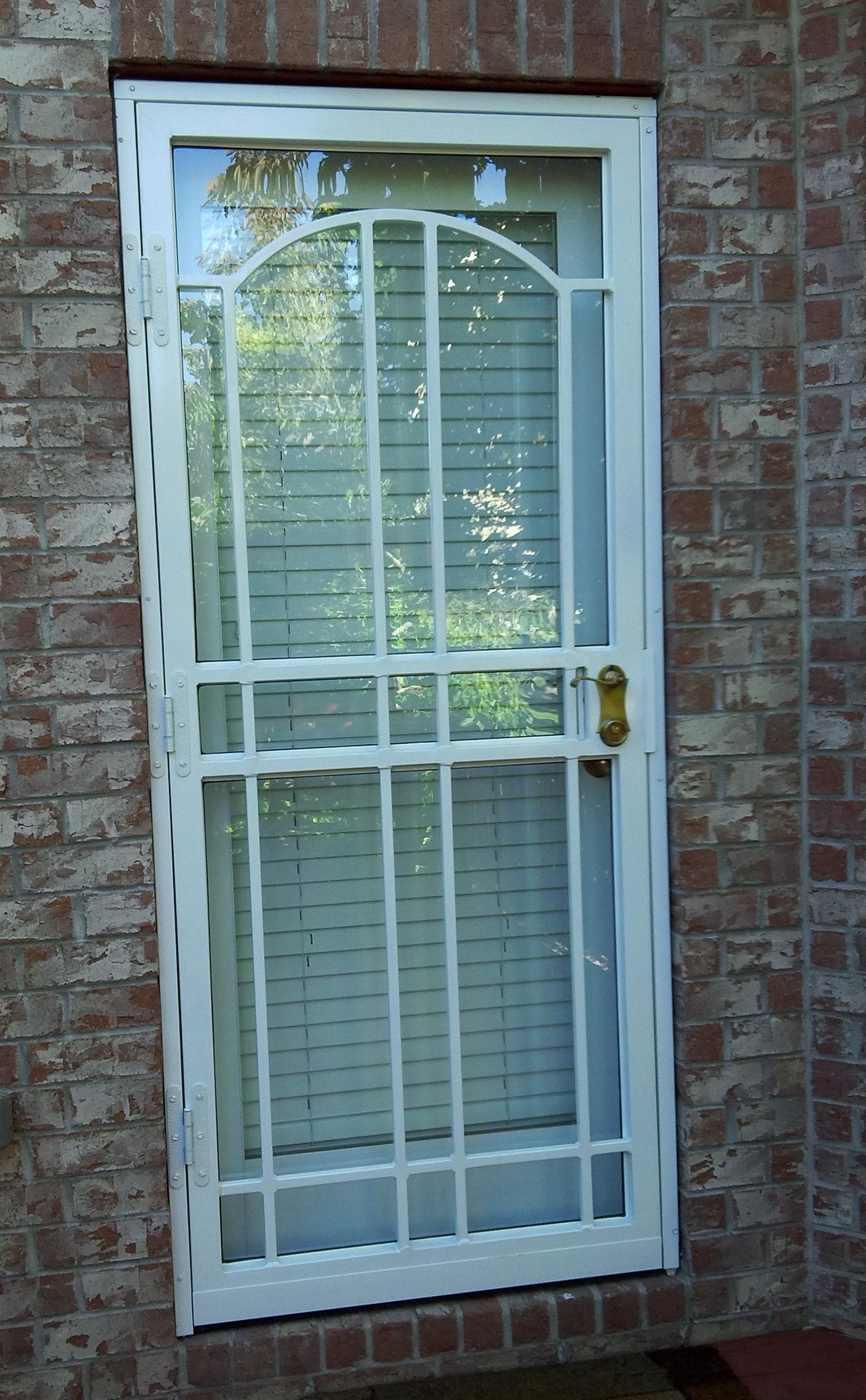 A white door with a brick wall behind it