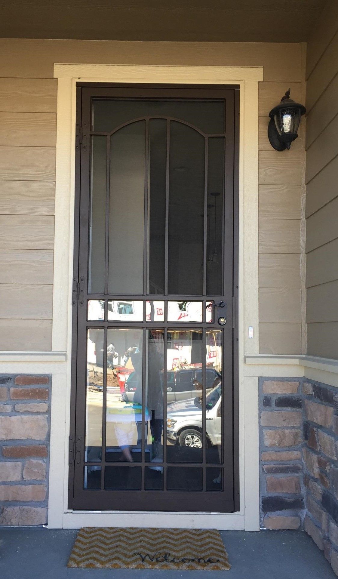 A door with a screen and a lamp on the side of it