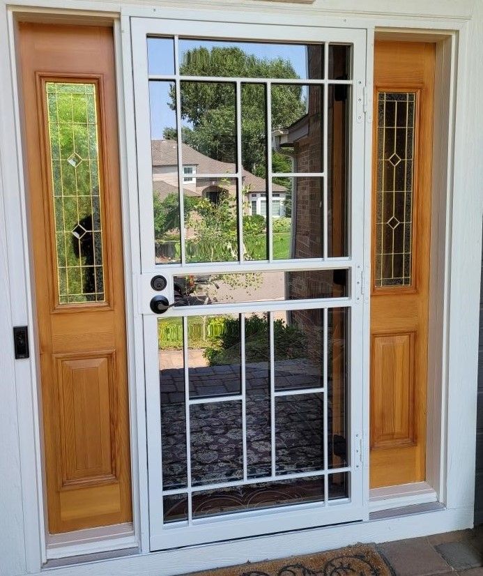 A front door with a screen door and two wooden doors.