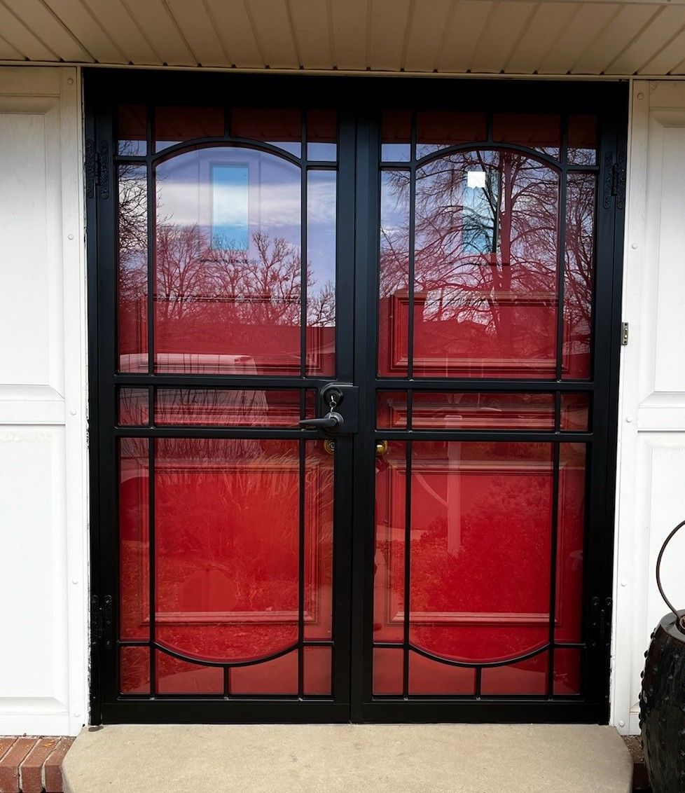A red door with a black frame on a white house