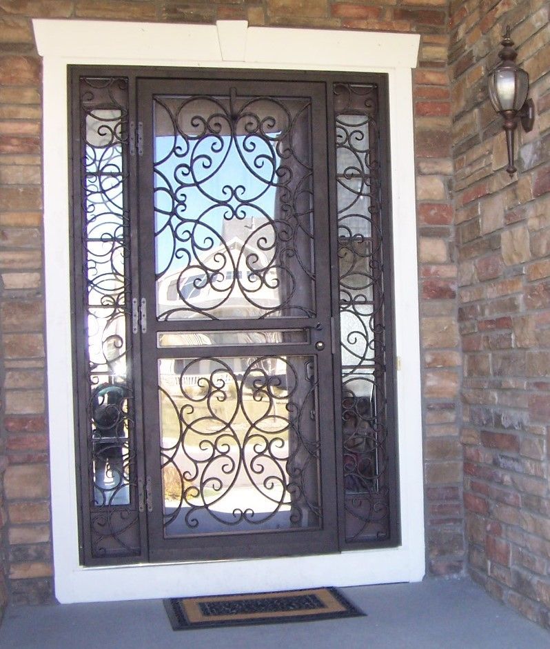 A wrought iron door with a brick wall behind it