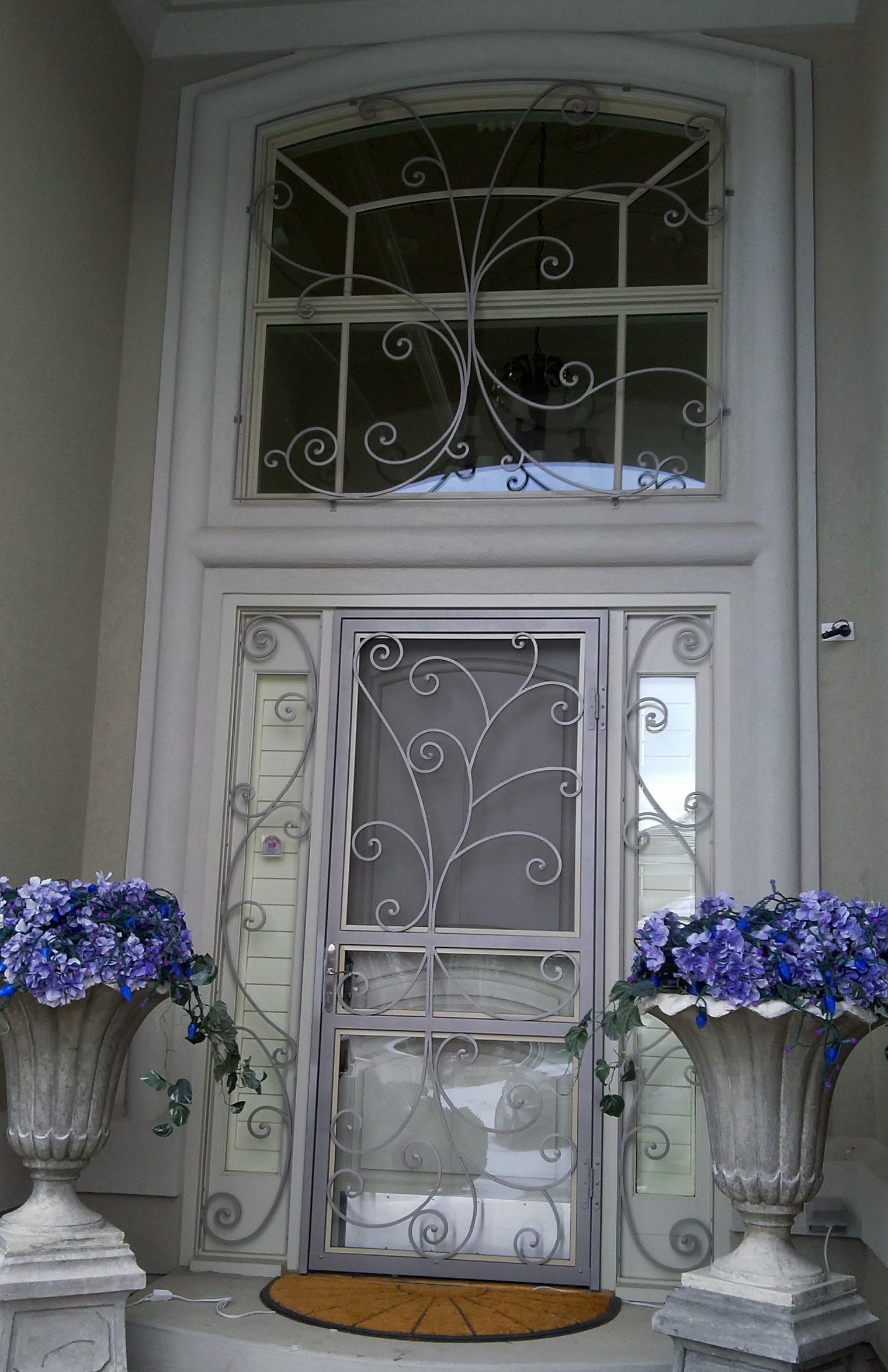 The front door of a house with purple flowers in vases