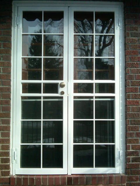 A white sliding glass door on a brick building