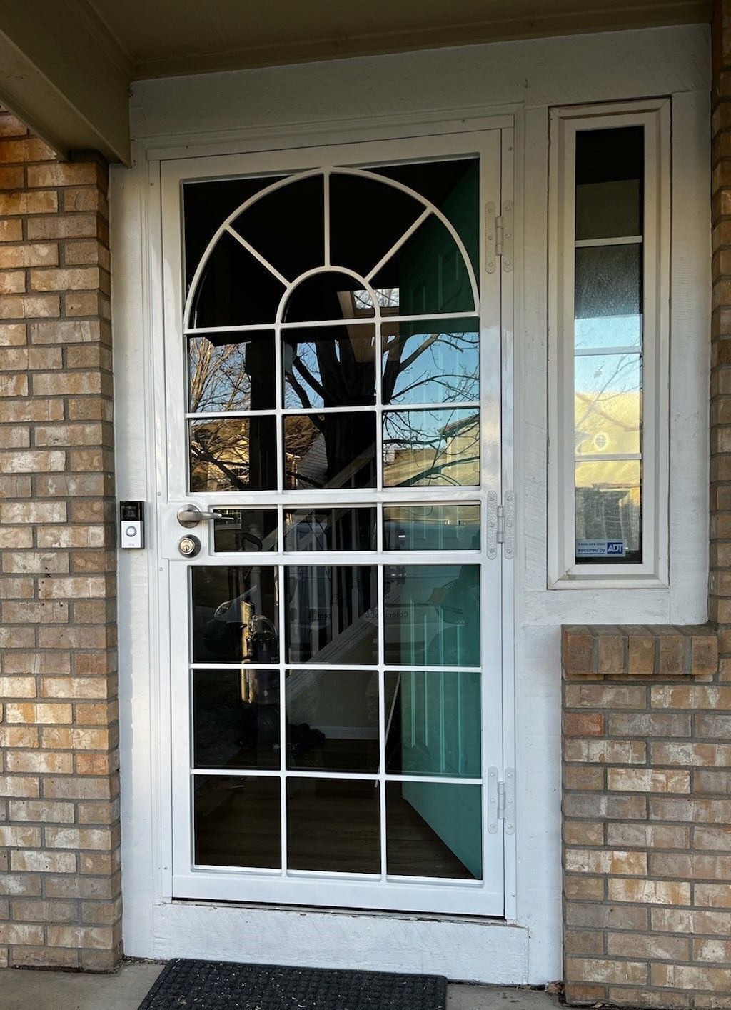 A white door with a brick wall behind it