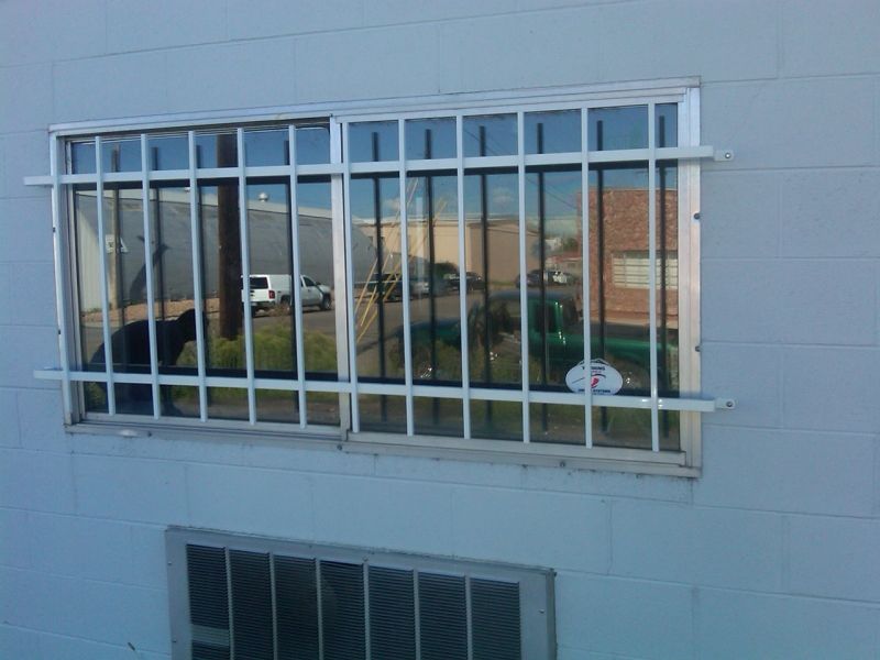 A white building with a window with bars on it