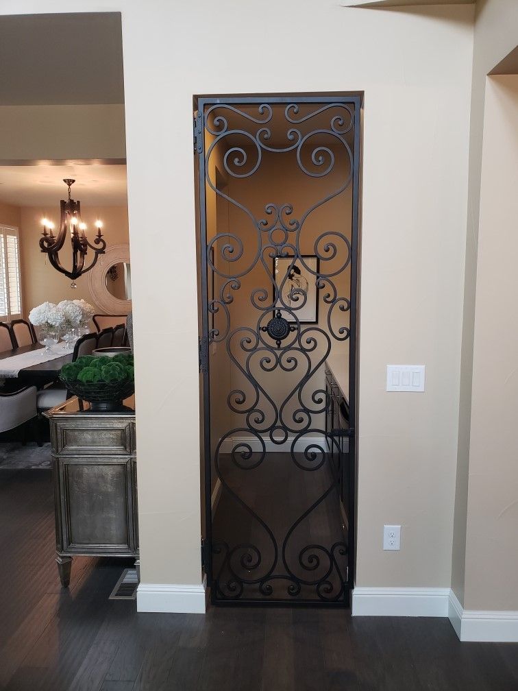 A wrought iron door is open to a living room.
