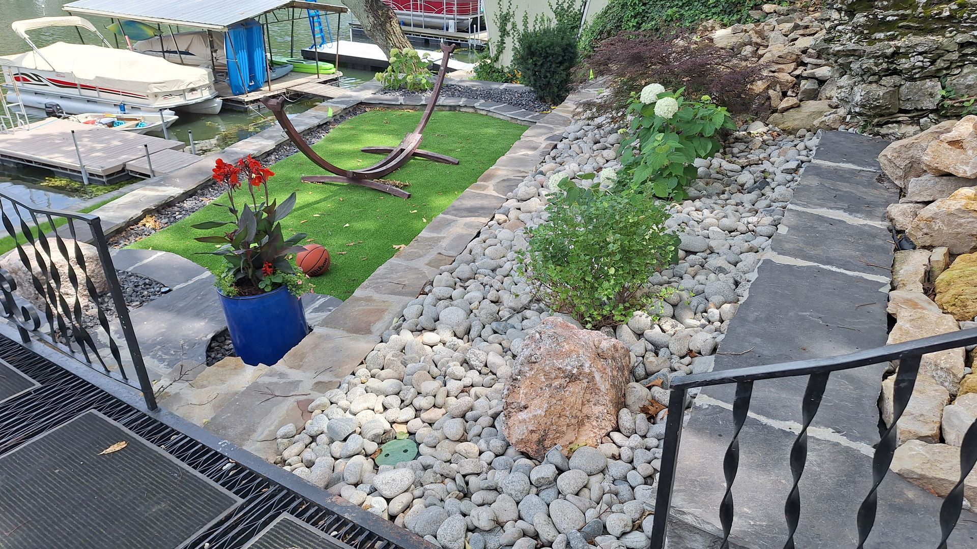 Rock garden path with stepping stones, succulents, and a small lawn with a curved hammock frame.