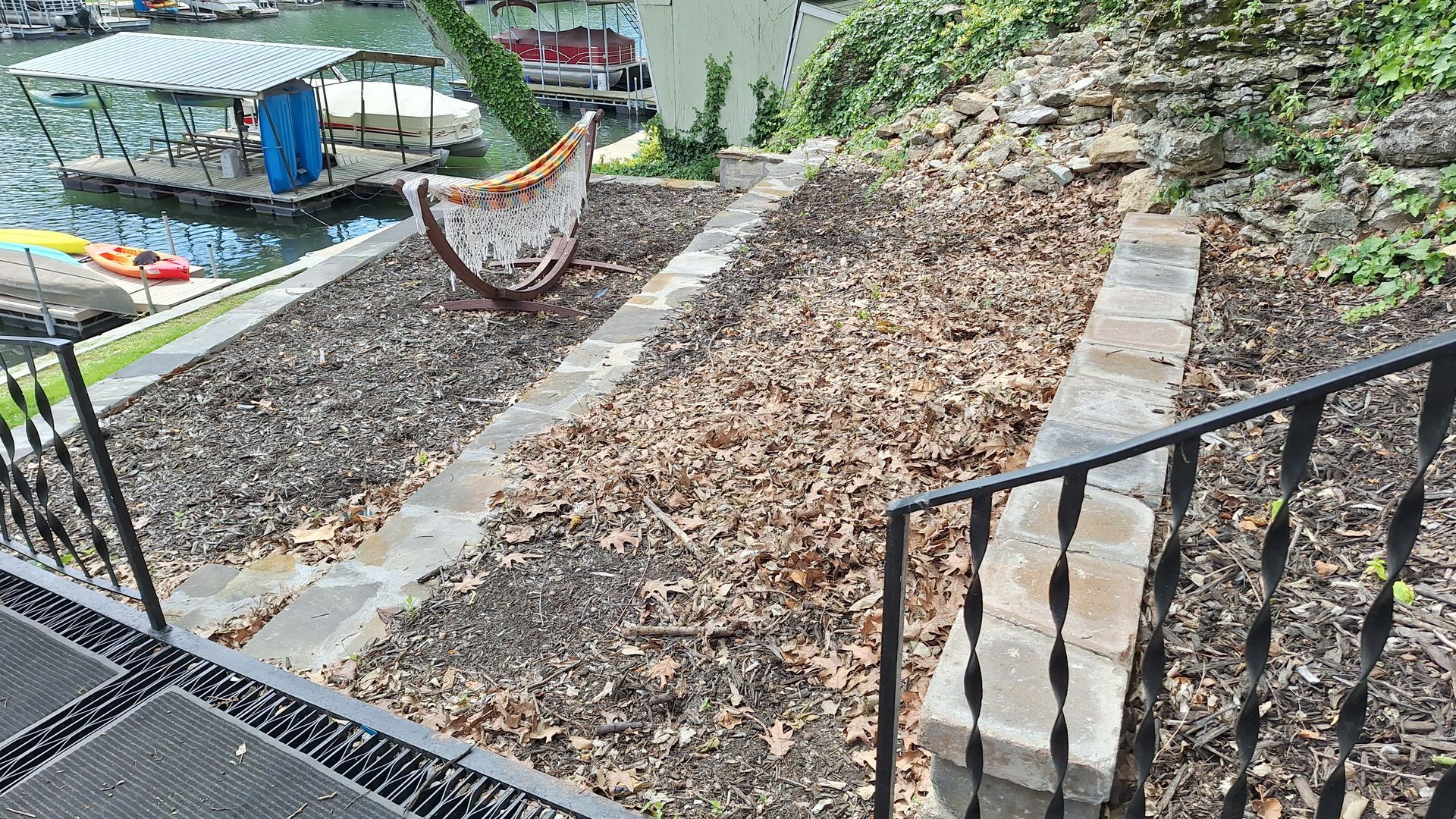 Steep stone-and-gravel garden path with railings and a hammock beside a house