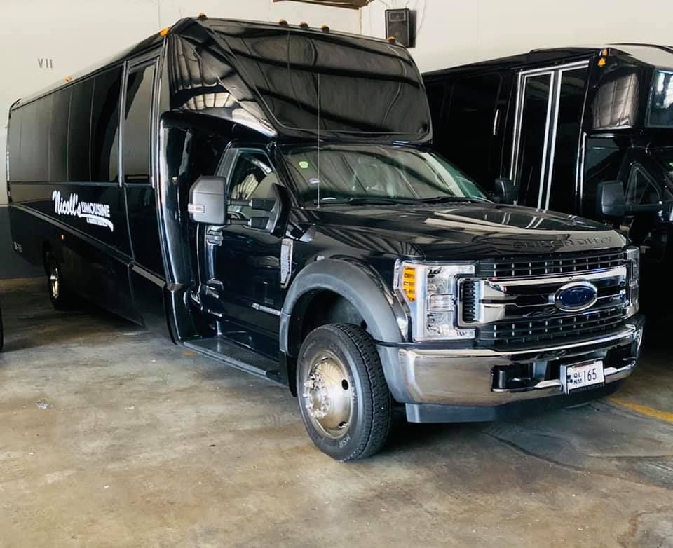 Black Ford shuttle bus parked in a garage.