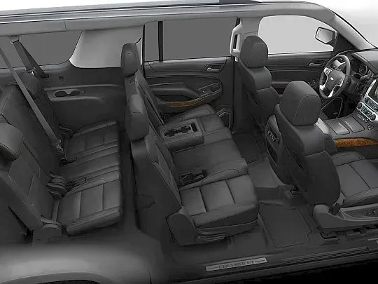 Interior view of a dark gray SUV with three rows of seats; the front seats are visible near the steering wheel.