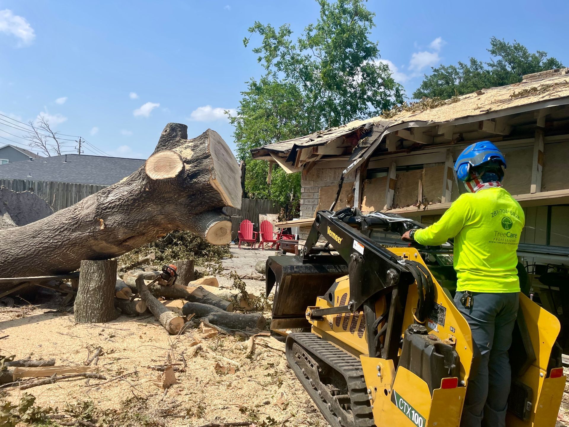 A man is driving a tractor next to a large tree stump.