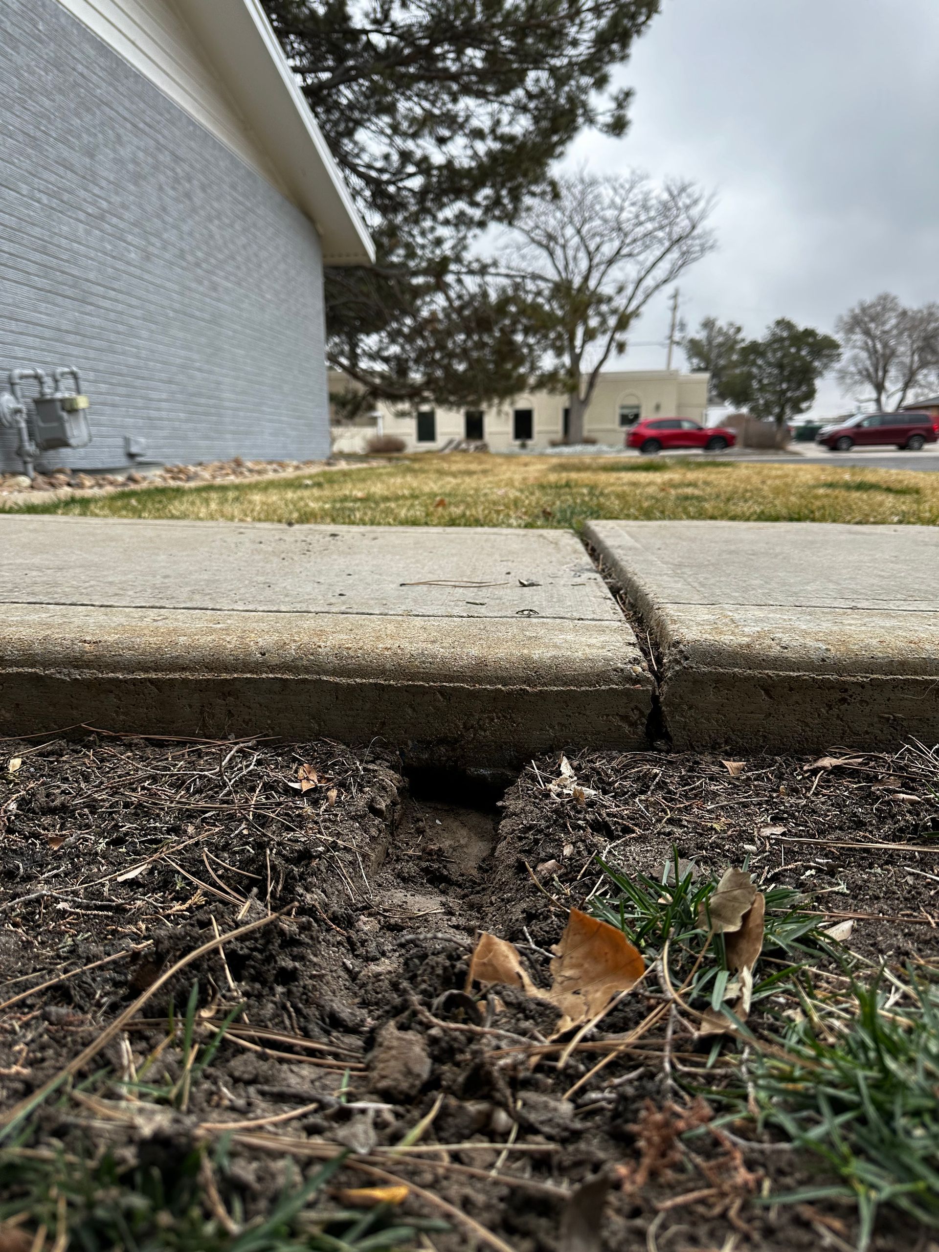 Tape measure showing a measurement of approximately 1 inch on a reddish-brown surface.