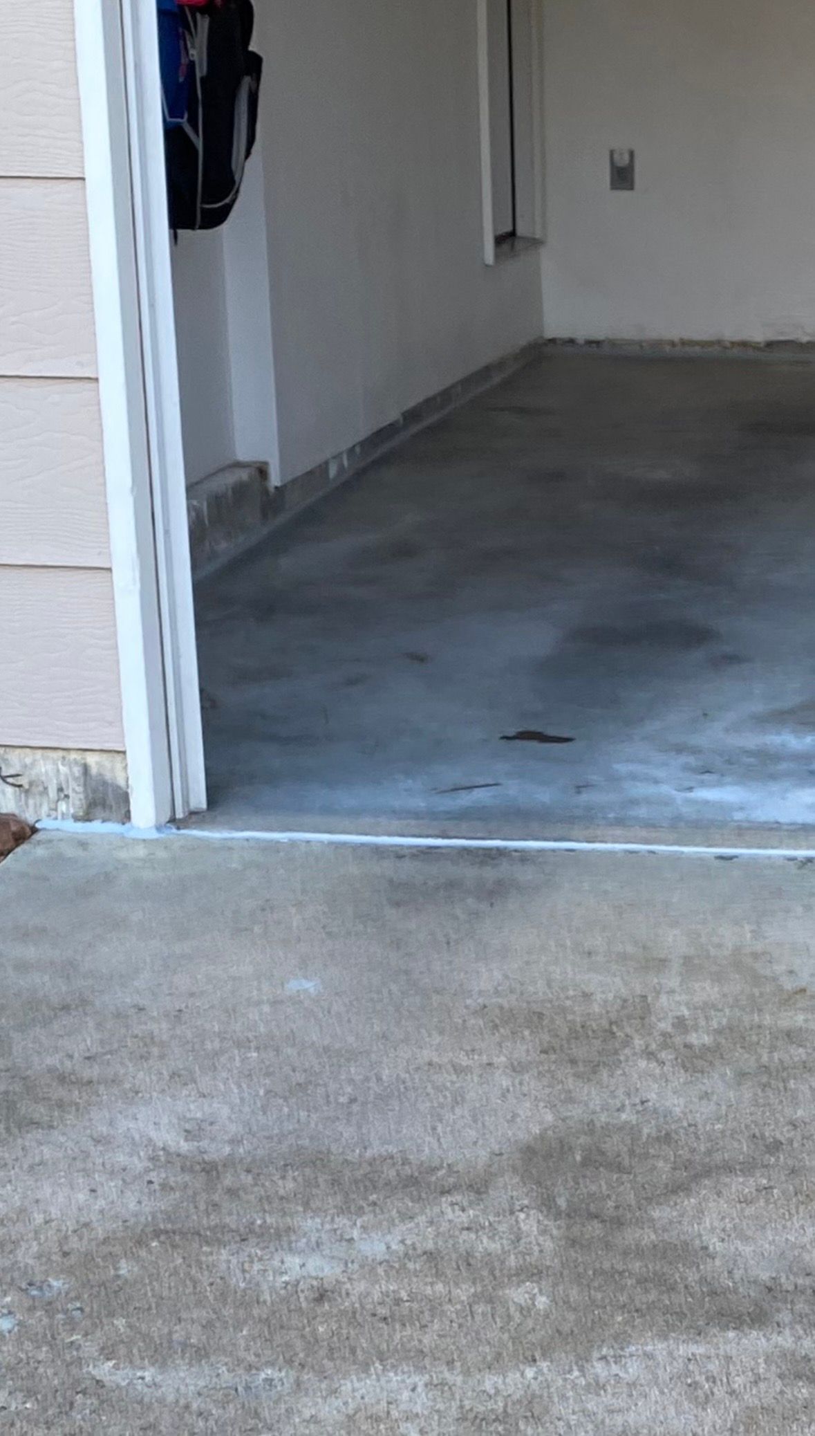 Garage entrance with concrete floor. The floor has a slightly darker appearance towards the interior.