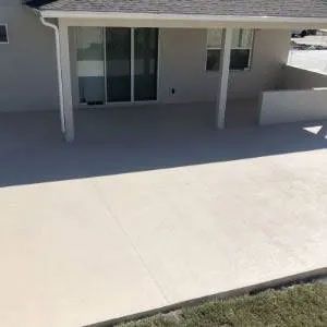 Concrete patio with a covered section extending from a house.