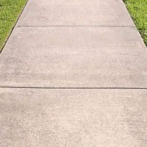Concrete sidewalk with grass on either side.