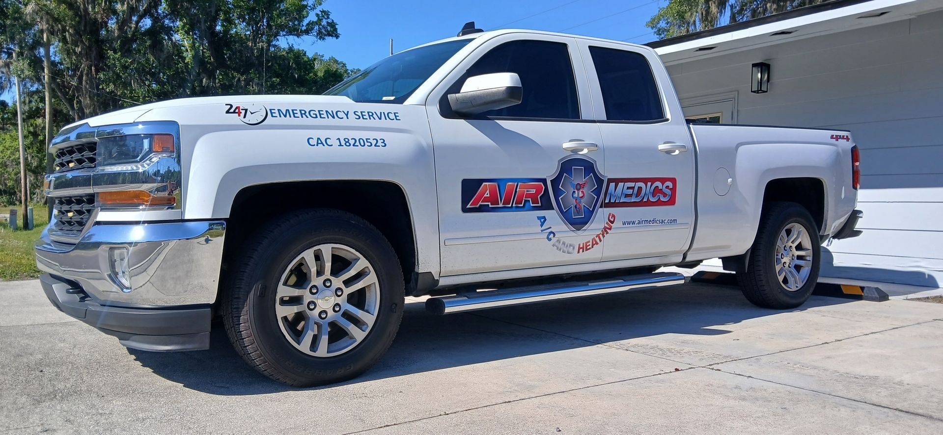 A white truck is parked in front of a house