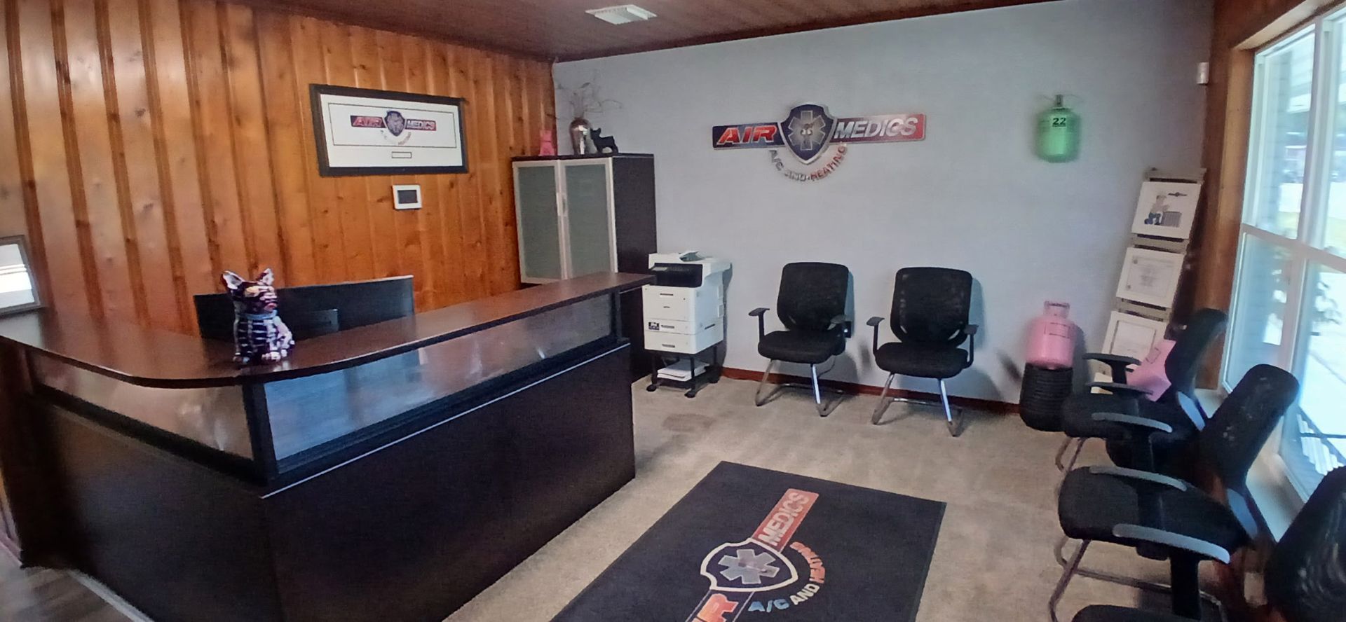 A waiting room with a desk, chairs, and a clock on the wall