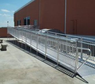 A ramp with a metal railing leading to a building