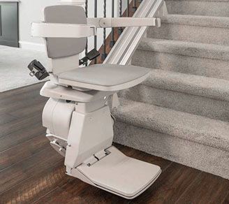 A white stair lift is sitting on top of a set of stairs.
