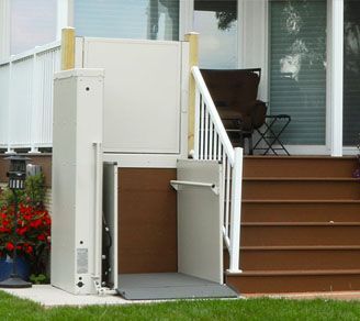 A wheelchair lift is attached to the side of a house.