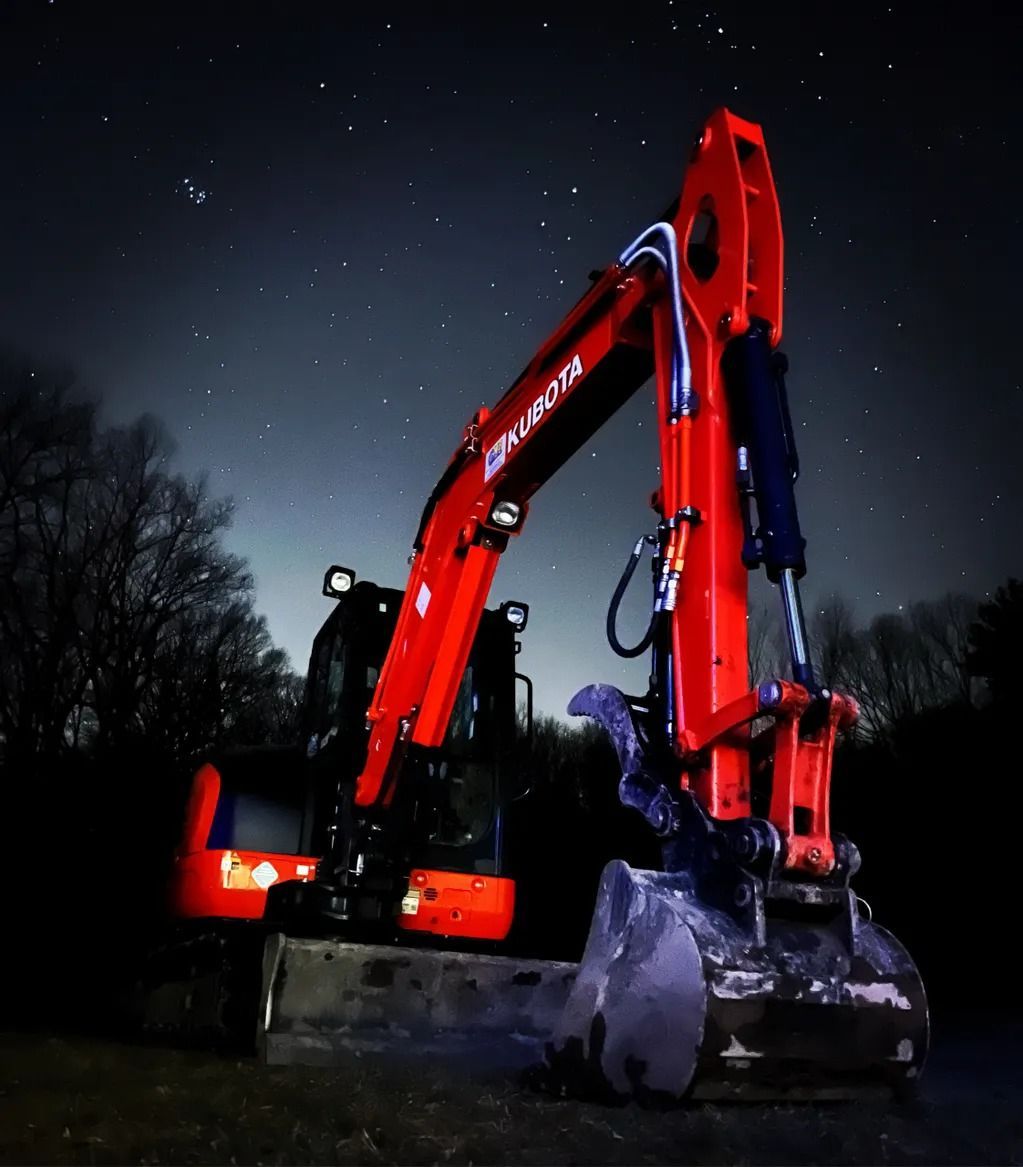 Bright red excavator at night under a starry sky.
