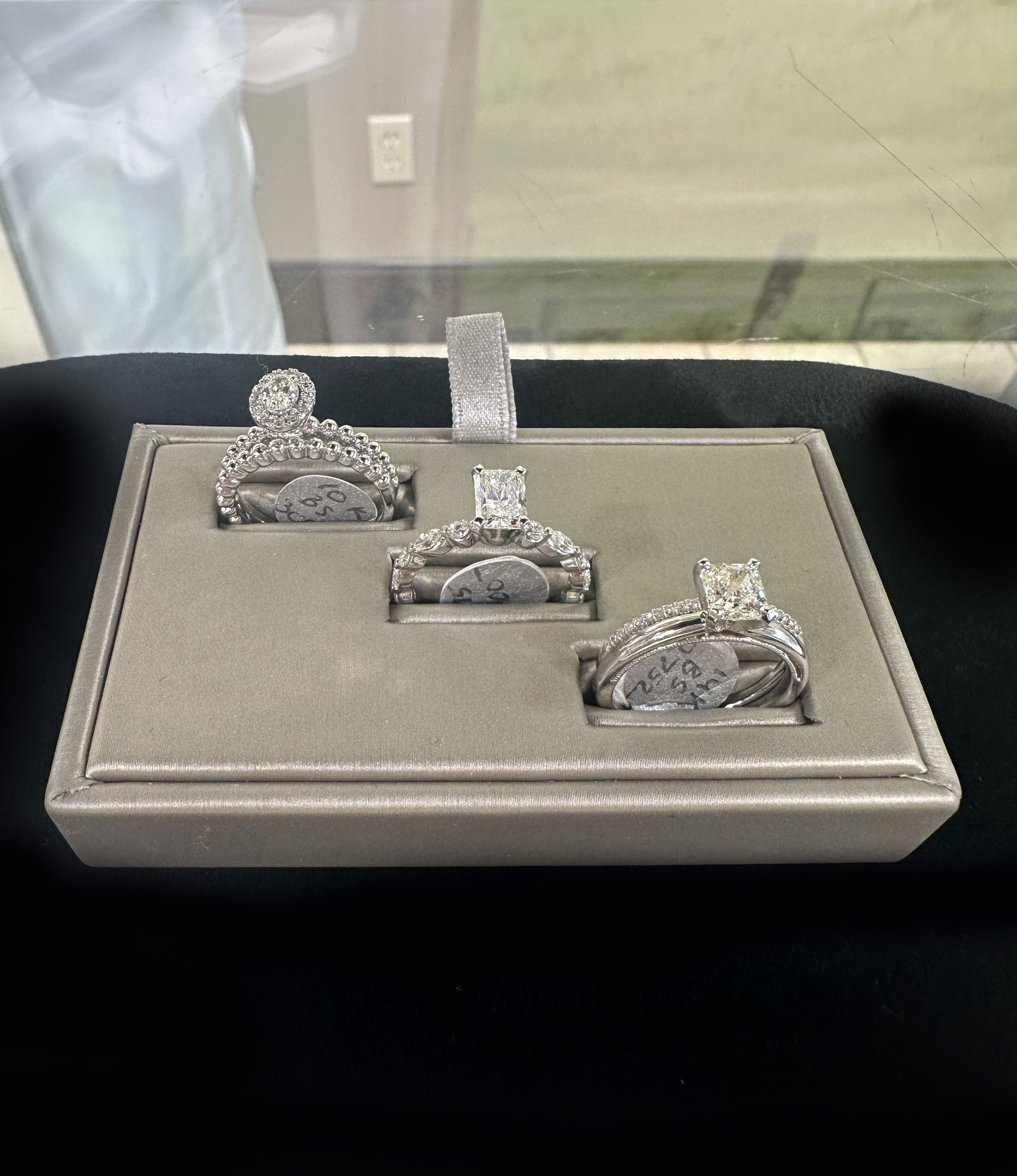 Three rings are displayed on a tray on a table.