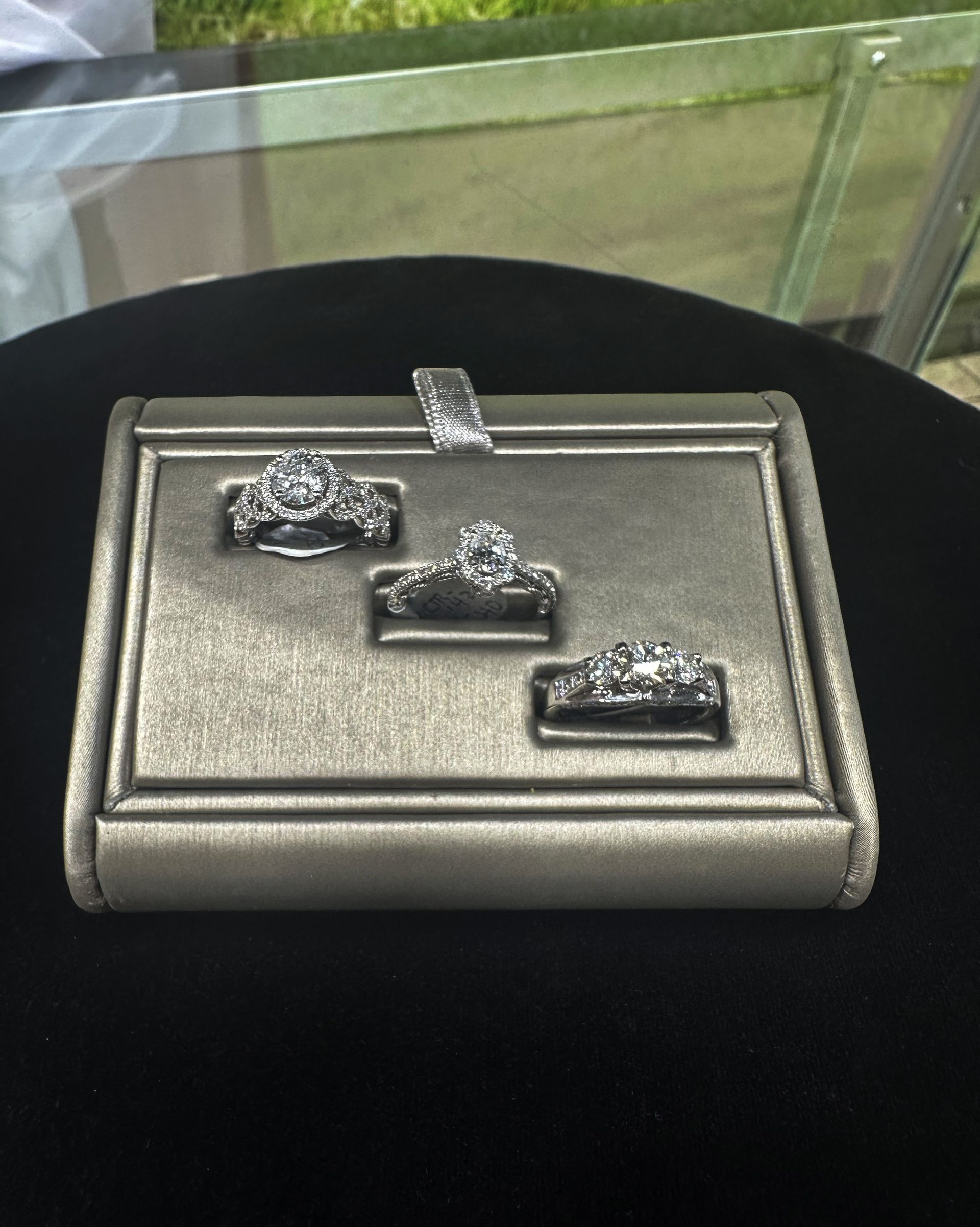 Three rings are sitting on a display case on a table.