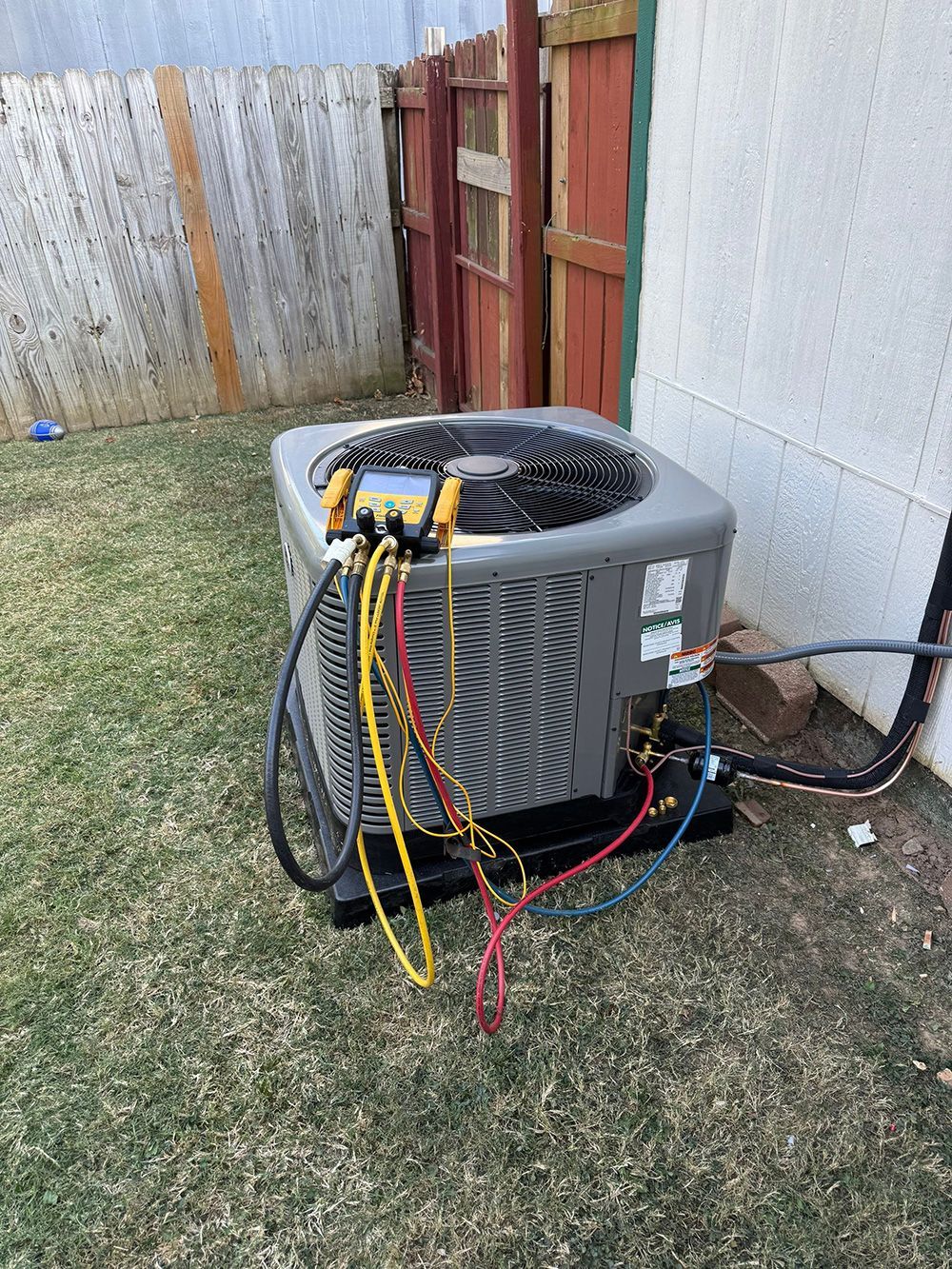 A large air conditioner is sitting on top of a lush green lawn.