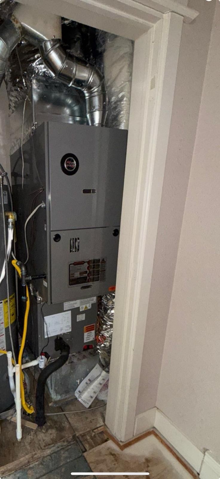 An air conditioner is sitting in a room next to a door.