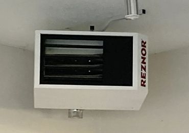 A white heater is hanging from the ceiling in a room