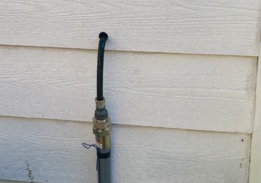 A gas hose is attached to the side of a house