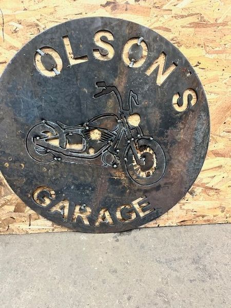 Metal sign with cut-out text and motorcycle silhouette: 