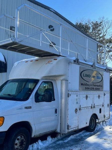 White service truck with overhead platform, parked in snow.