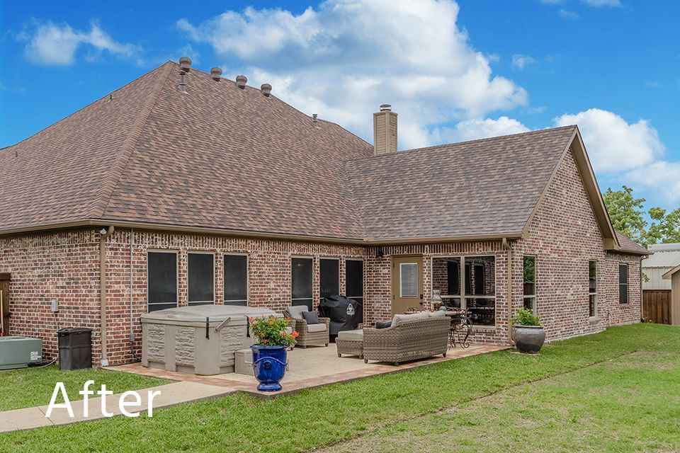 A brick house with a patio and a hot tub in the backyard.