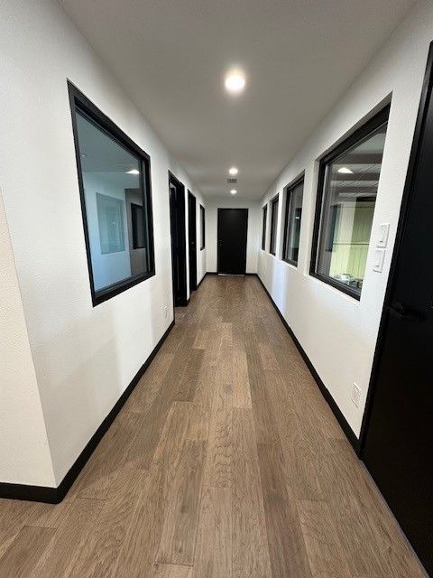 A long hallway with lots of windows and doors