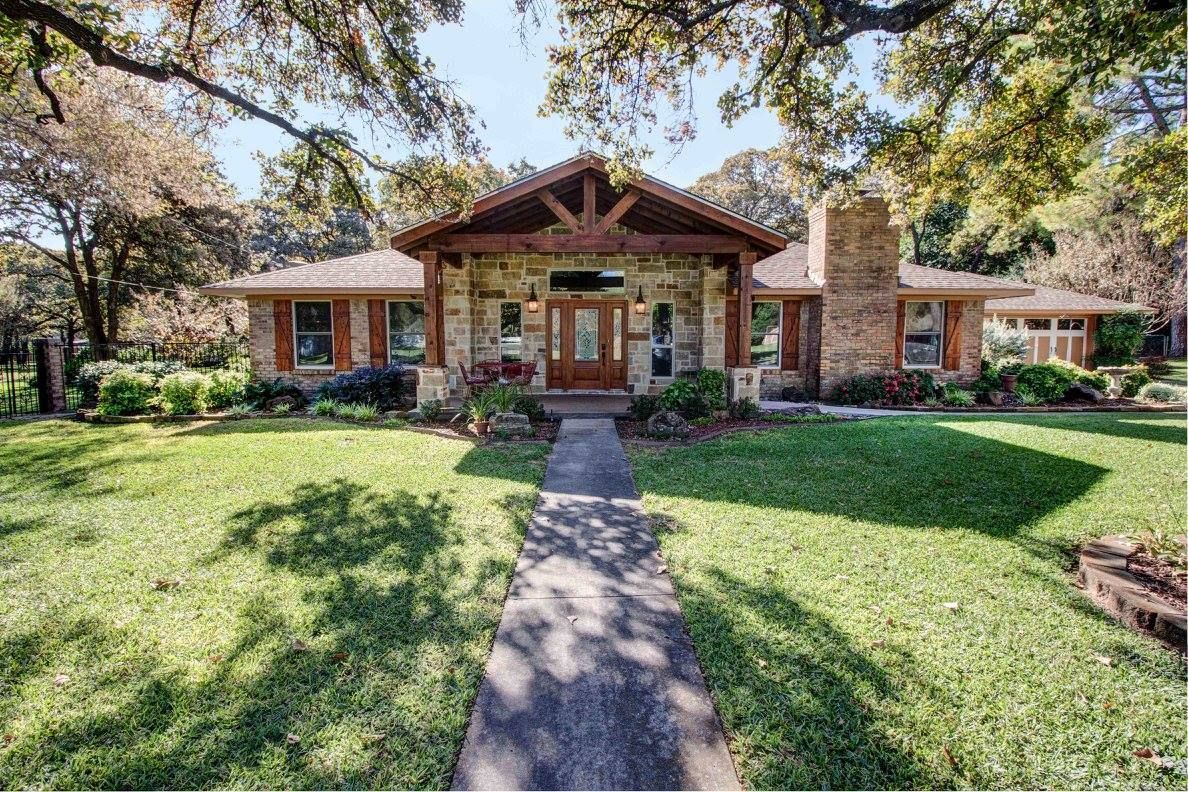 A large house with a lush green lawn and a walkway leading to it