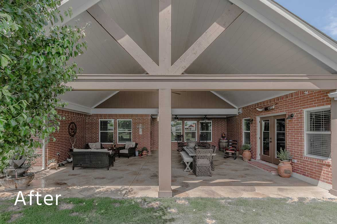 A covered patio of a brick house