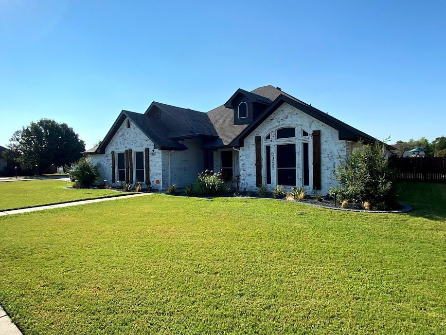 A large white house with a lush green lawn