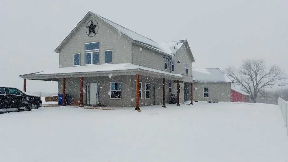 A large house with a star on the roof covered in snow