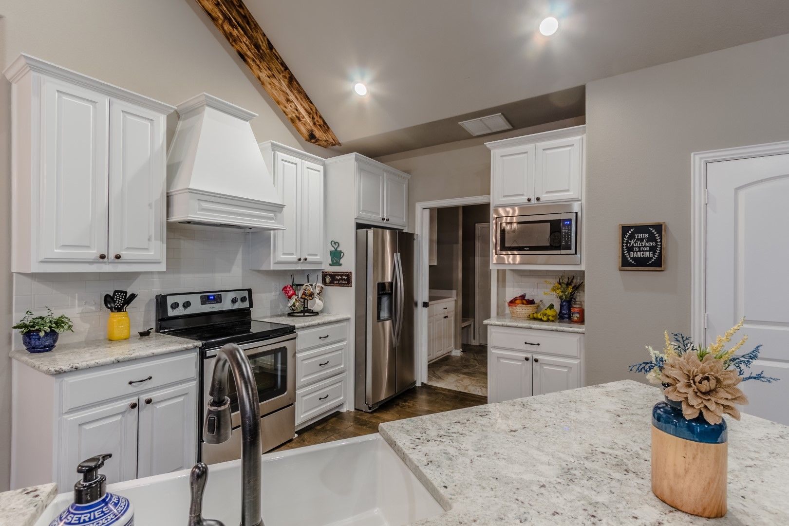 Kitchen with white cabinets, stainless steel appliances, and a farmhouse sink