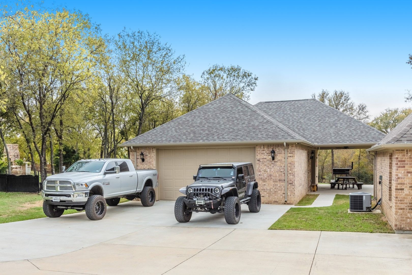 A truck and a Jeep parked in front of a brick garage