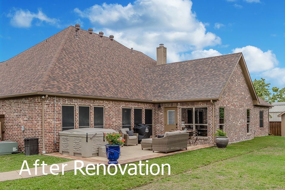 A picture of a brick house with a patio