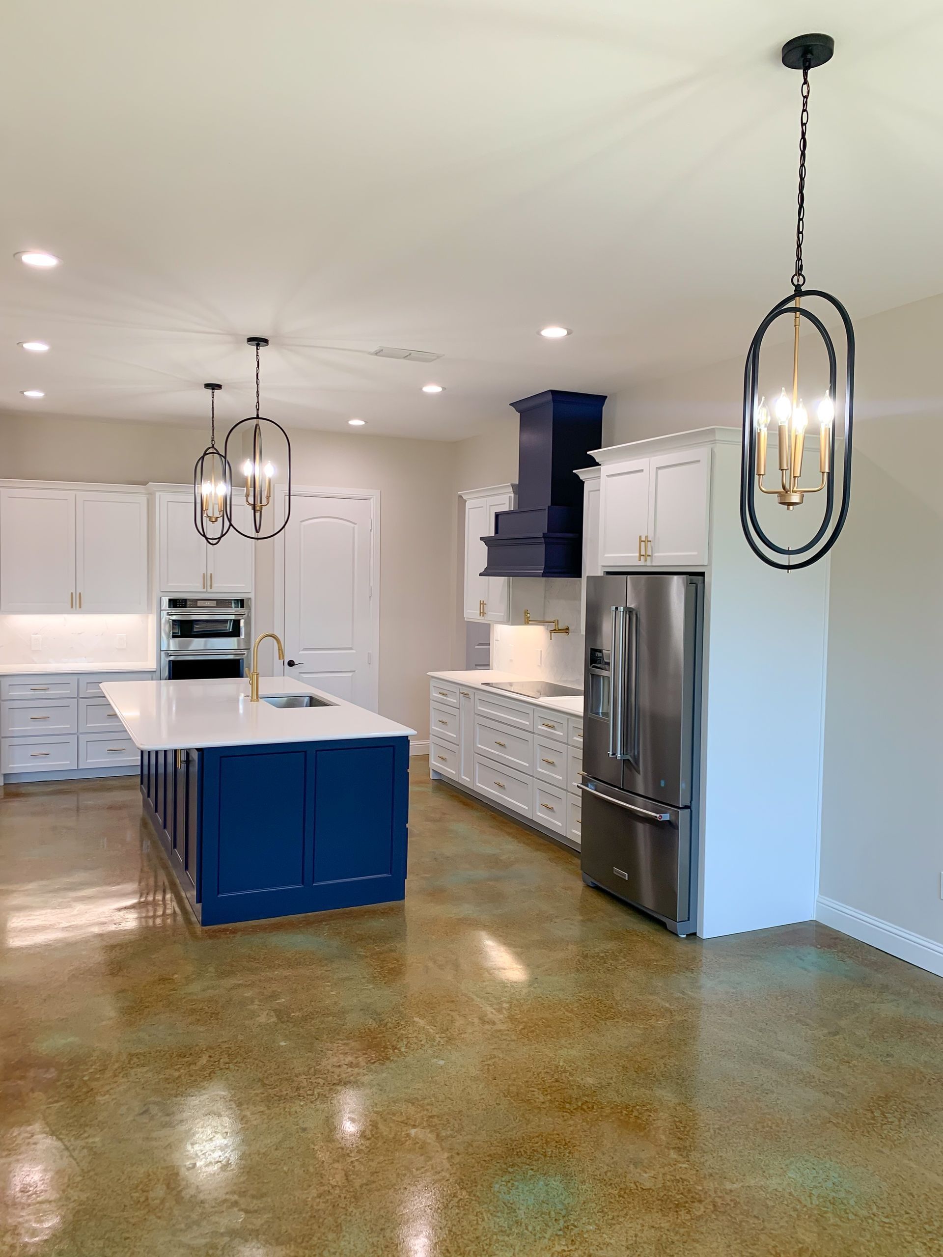 A kitchen with white cabinets, stainless steel appliances, and a blue island